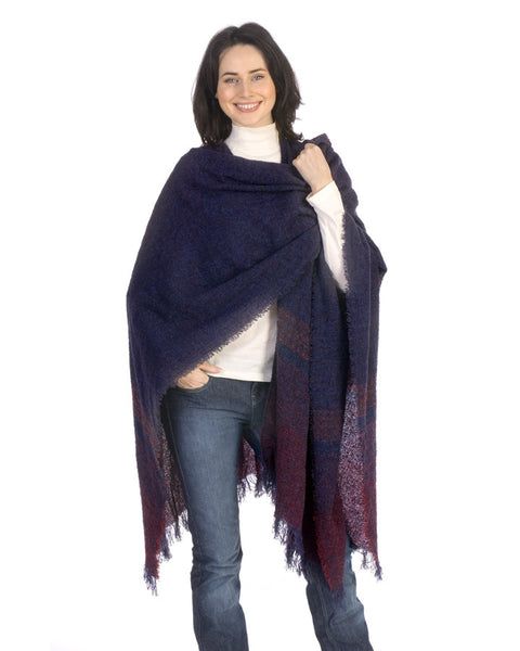 A smiling women wears the Blueberry wine Celtic Ruana with dark purple and pink hues in Irish wool